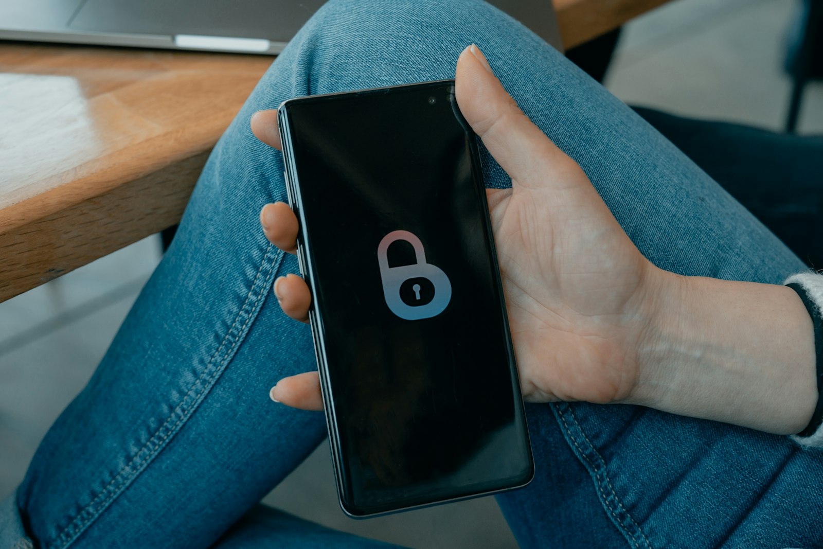 A hand holding a phone showing a padlock icon